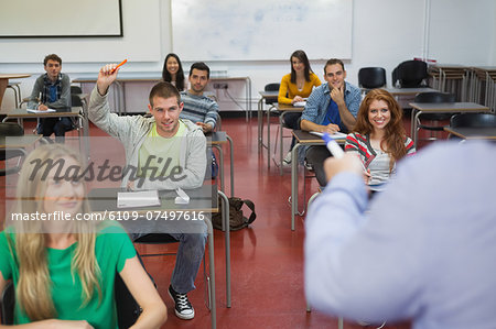 Student raising his hand to ask a question in class at the university