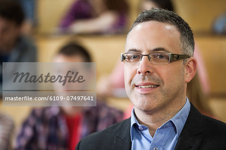 Happy lecturer looking at camera in lecture hall in college