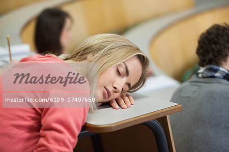 Blonde student sleeping in a lecture hall in college