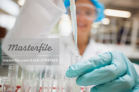 Student using pipette holding test tube in lab at college