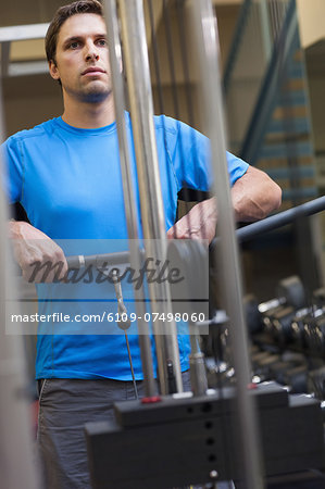 Determined sporty young man doing exercises in the gym on lat machine