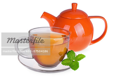 Glass cup of tea with mint leaves and orange teapot isolated on white background