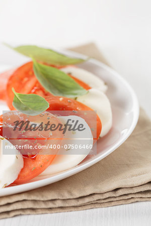 light traditional caprese salad, close up on white plate