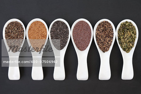 Seed food selection in porcelain scoops over slate background.