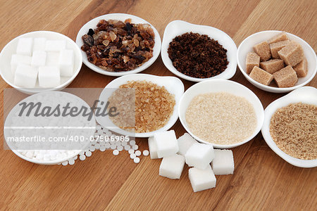 Sugar selection in white porcelain dishes over oak background.