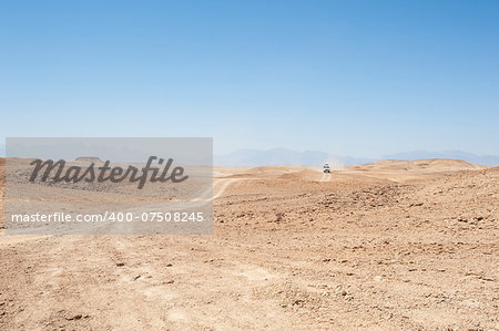 Desert safari in an off road vehicle across an empty arid desert landscape