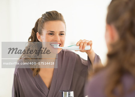 Young woman brushing teeth in bathroom