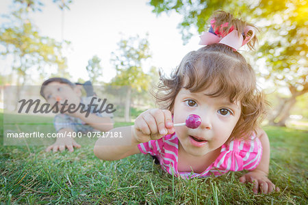 Cute Baby Girl and Brother with Lollipops in the Park.