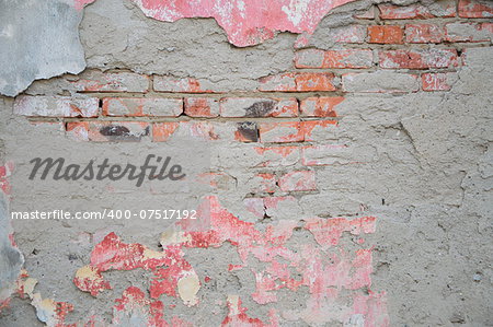 Old brick wall with crumbling plaster