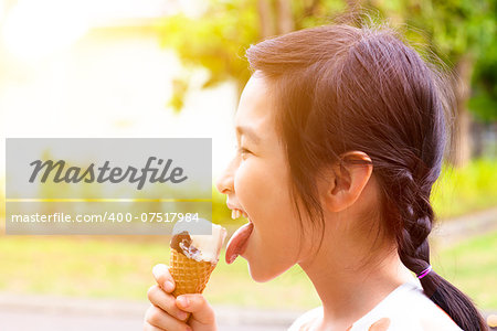 happy little girl eating popsicle with sunset background