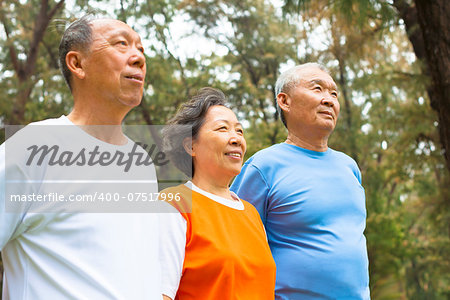 happy senior sibling standing a row in park