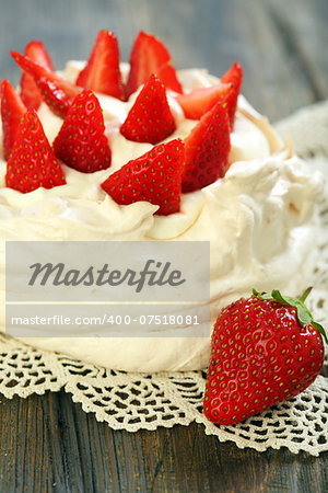 Dessert with whipped cream and strawberries on a wooden table.