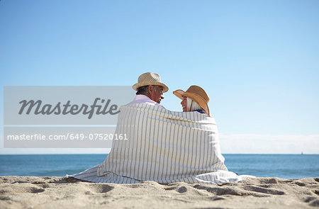 Couple wearing straw hats on beach