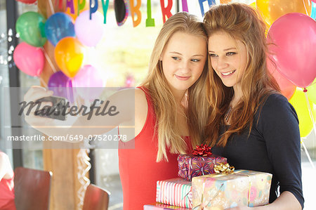 Two teenage girls taking selfie at birthday party