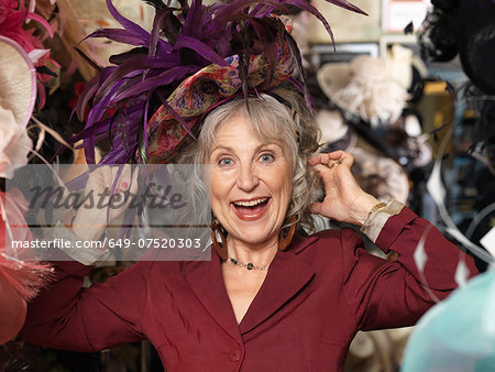 Glamorous senior woman trying on hat