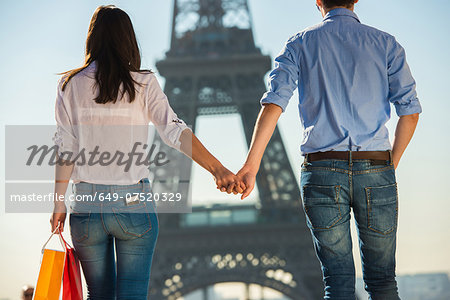 Young couple strolling in front of  Eiffel Tower, Paris, France