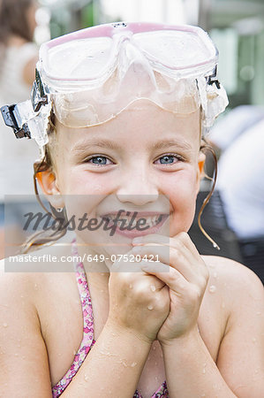 Girl with goggles on head clasping hands