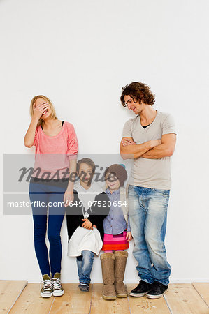 Studio shot of couple with son and daughter in oversize clothes