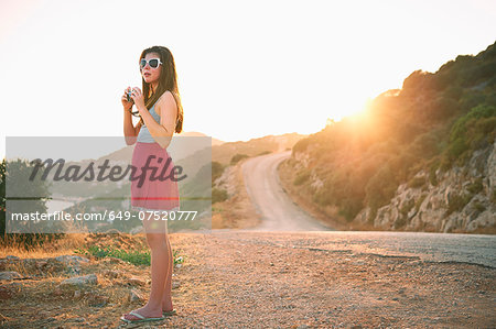 Girl holding camera at sunset, Kas, Turkey