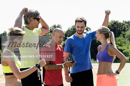 Mature trainer celebrating timing with group of adults