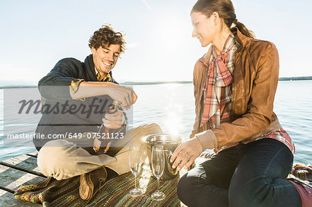 Couple by lake with wine Couple by lake with wine