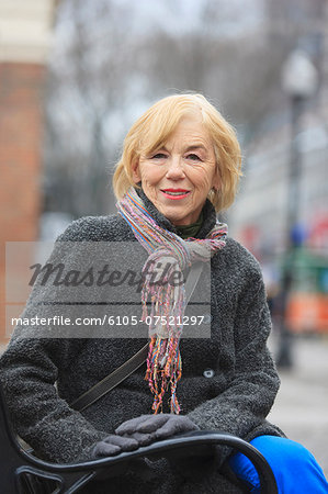 Portrait of a woman sitting on a bench and smiling, Boston, Suffolk County, Massachusetts, USA