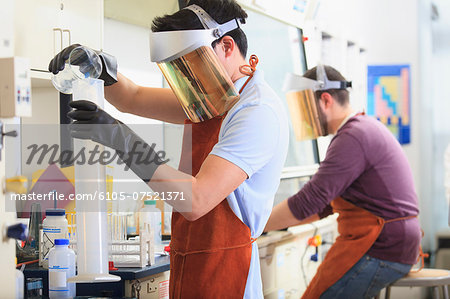 Engineering students wearing protective equipment while working with chemicals in a laboratory