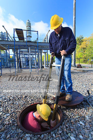 Power engineer entering manhole at a high voltage power distribution station, Braintree, Massachusetts, USA