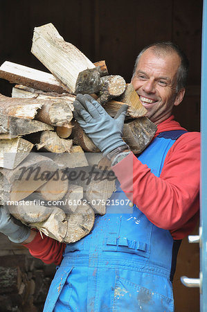 Smiling man carrying firewood, Ronneby, Blekinge, Sweden