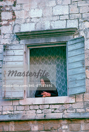 A woman watching from her window in Kotor, Montenegro, - formerly Yugoslavia - a UNESCO World Heritage Site.