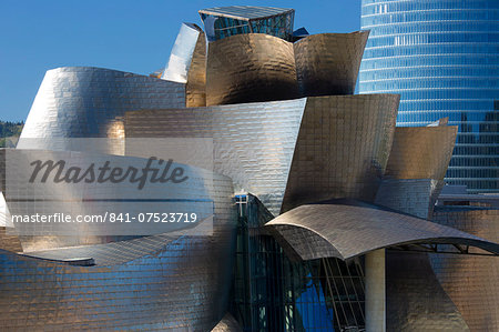 Architect Frank Gehry's Guggenheim Museum futuristic design in titanium and glass and Iberdrola Tower behind at Bilbao, Spain