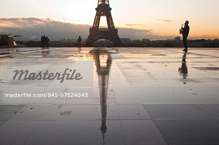 A man playing a saxophone in front of the Eiffel Tower, Paris, France, Europe