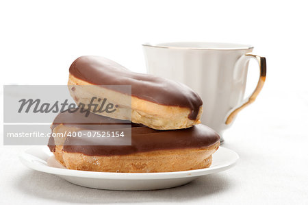 Chocolate eclairs on plate on white background