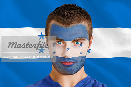 Composite image of serious young honduras fan with facepaint against digitally generated honduras national flag