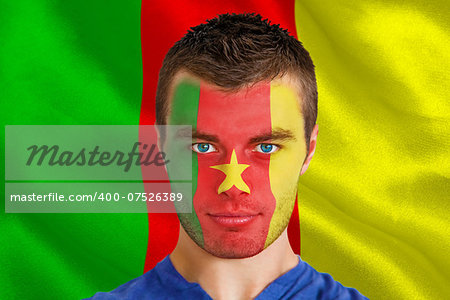 Composite image of serious young cameroon fan with facepaint against digitally generated cameroon national flag