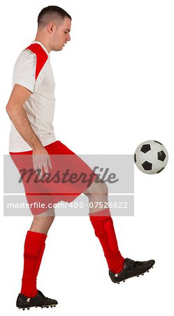 Fit football player playing with ball on white background