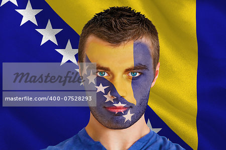 Composite image of serious young football fan in face paint against digitally generated bosnian flag