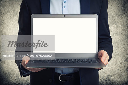 Businessman showing laptop computer with blank screen