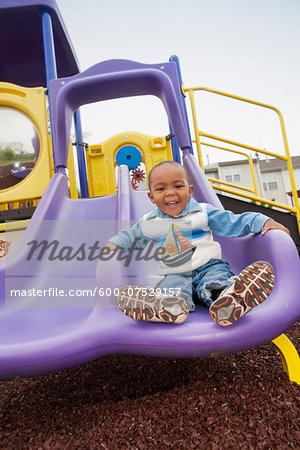 Portrait of Boy Playing on Playground Slide, Maryland, USA