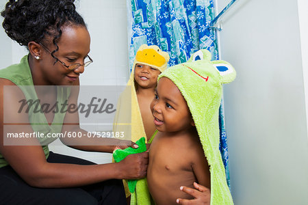 Mother Helping Boys put on Hooded Towels after Bath