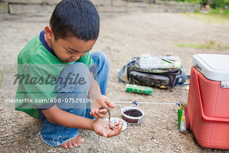 Crouching Boy preparing Worm for Fishing, Lake Fairfax, Reston, Virginia, USA