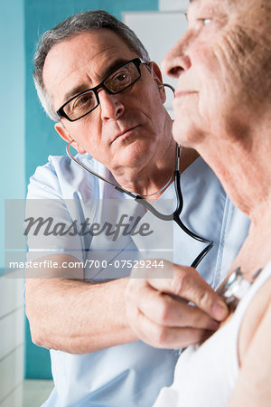 Senior, male doctor using stethoscope on senior, male patient, in office, Germany
