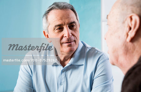 Senior, male doctor conferring with senior, male patient in office, Germany Senior, male doctor conferring with senior, male patient in office, Germany