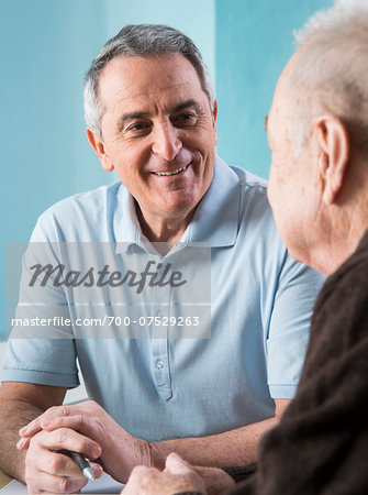 Senior, male doctor conferring with senior, male patient in office, Germany Senior, male doctor conferring with senior, male patient in office, Germany
