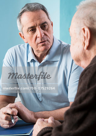 Senior, male doctor conferring with senior, male patient in office, Germany