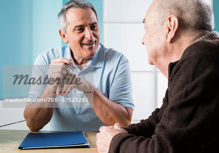 Senior, male doctor conferring with senior, male patient in office, Germany