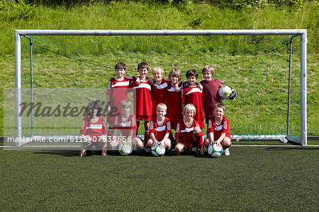 Group of boys posing in front of soccer goal, Munich, Bavaria, Germany
