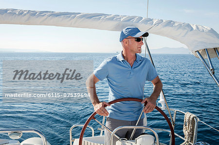 Mature man on sailboat, steering, Adriatic Sea, Croatia