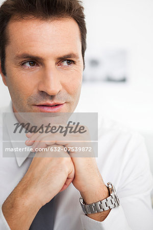 Businessman with hands clasped under chin, portrait