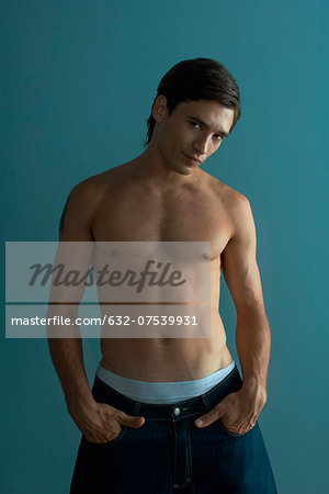 Muscular barechested man with hands in pockets